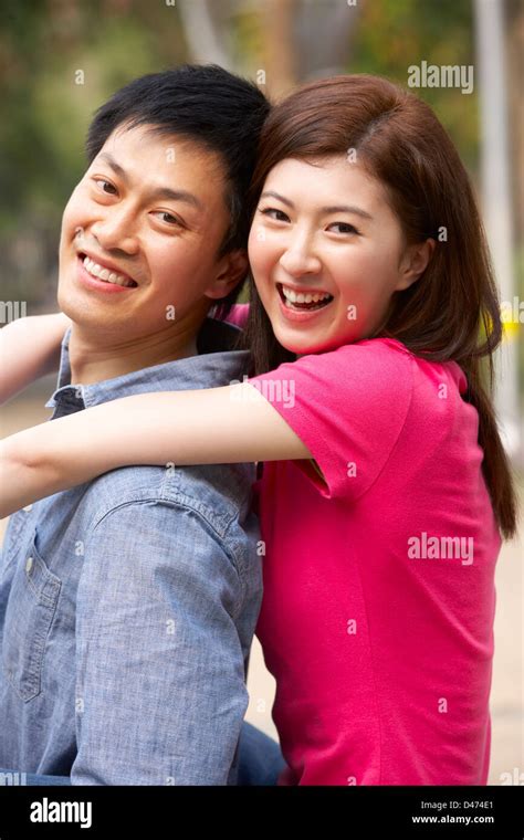 Young Chinese Couple Relaxing In Park Together Stock Photo Alamy