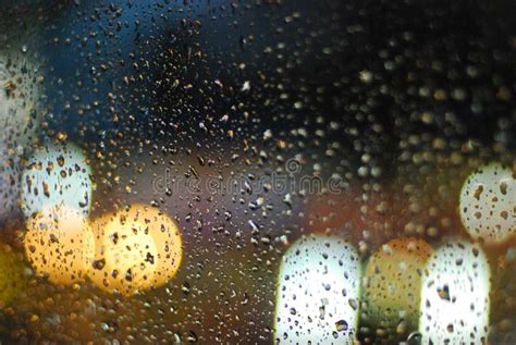 Rain Drops On Window With Road Light Bokeh Background Stock Photo