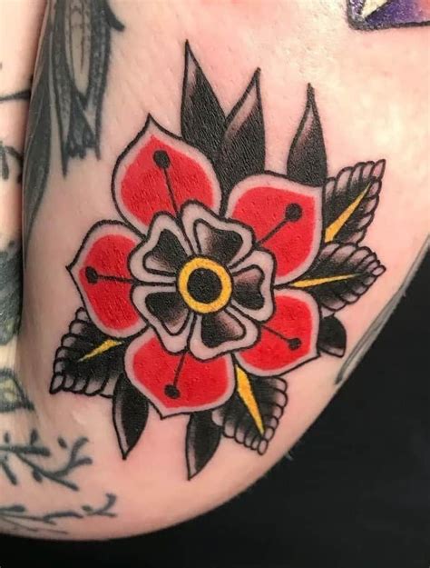 A Close Up Of A Persons Leg With A Flower Tattoo Design On It