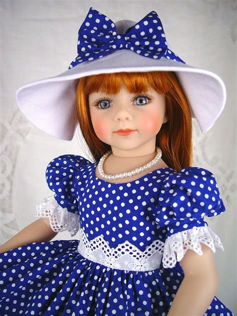 A Doll With Red Hair Wearing A Blue And White Polka Dot Dress Hat And