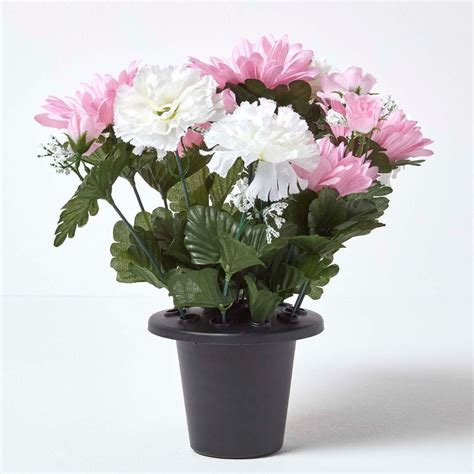 Artificial flowers are just as diverse as regular flowers and are nearly identical in appearance. Baby Pink and White Artificial Flowers in Grave Vase
