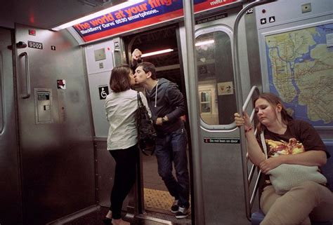 Two People Kissing On The Subway Train While Others Wait For Their Turn