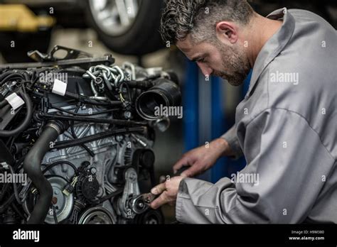 Car Mechanic In A Workshop Repairing Engine Stock Photo Alamy