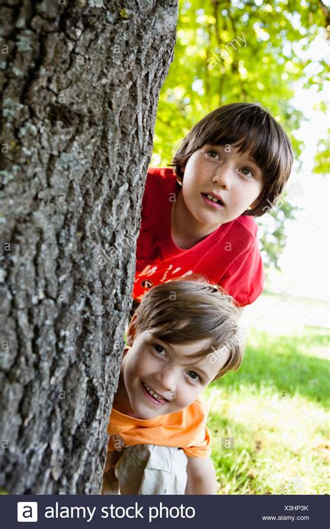 Two Boys Hiding Behind Tree Close-Up Stock Photo: 277600391 - Alamy
