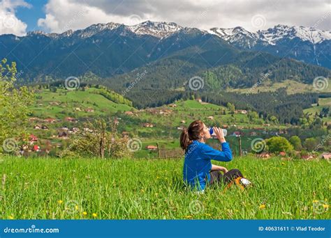 Young Woman Resting On Hill With Beautiful Mountain Scenery On