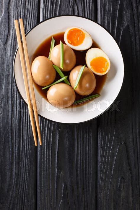 Thai spicy and sour soup with mushrooms, tomatoes, scallions, and egg. Nitamago eggs in soya marinade with ... | Stock image | Colourbox