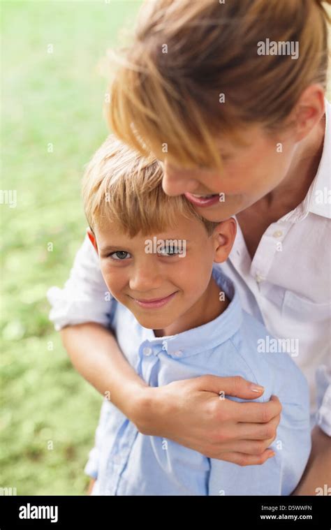 Mother Hugging Son In Park Stock Photo Alamy