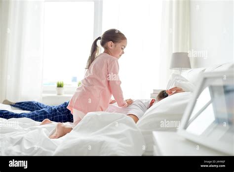 Little Girl Waking Her Sleeping Father Up In Bed Stock Photo Alamy