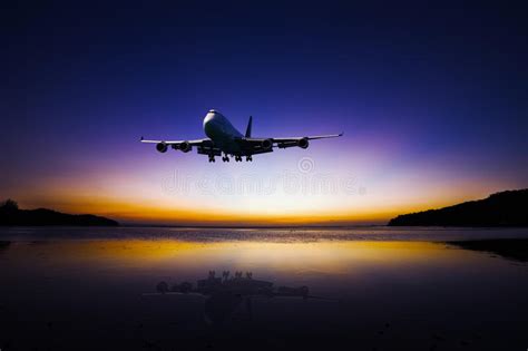 Airplane Flying On Colorful Evening Sky Over Sea At Sunset With Stock