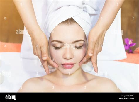 Beautiful Girl Enjoys Face Massage In Spa Salon Procedures For Beauty And Rejuvenation Stock