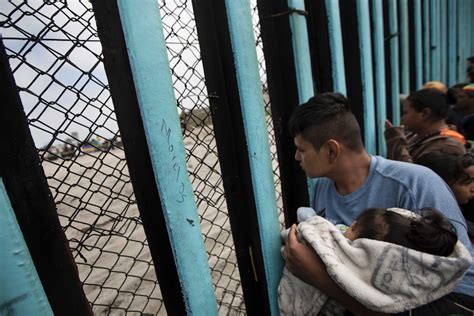 asylum seekers climb us border wall as migrant caravan gathers on mexican side abc news