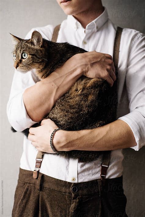 A Young Man Is Holding A Cat By Laika One Stocksy United