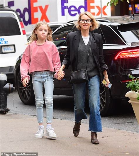 The Mother And Daughter Are Walking Down The Street