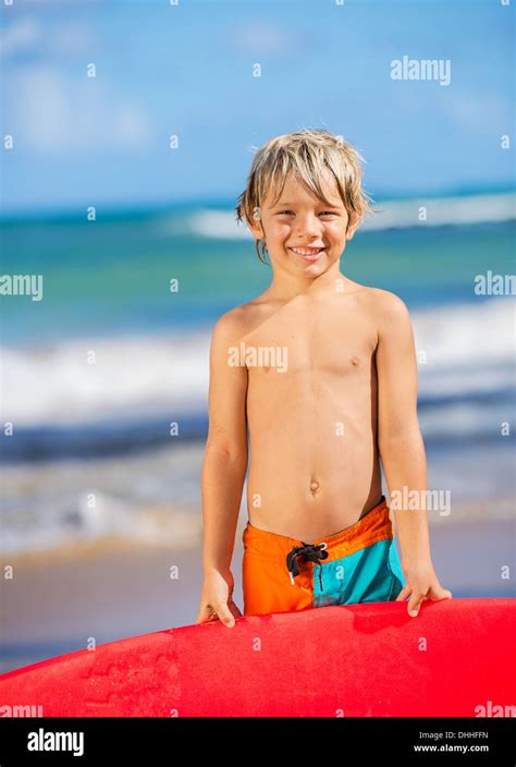 Young Surfer Happy Young Boy At The Beach With Surfboard Stock Photo