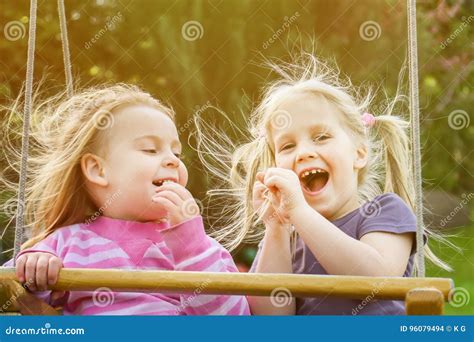 Deux Petites Filles Mignonnes Ayant Lamusement Sur Une Oscillation