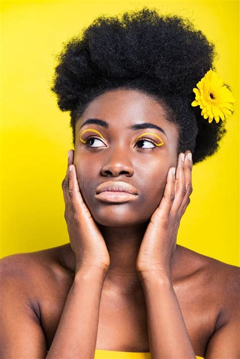 african american woman with flower in hair looking away isolated on yellow stock image image
