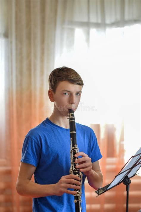 The Guy Plays The Clarinet Looks At The Music And Plays Music In A
