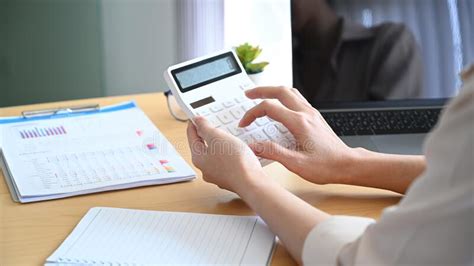 Female Accountant Using Calculator For Calculating Finance At Office