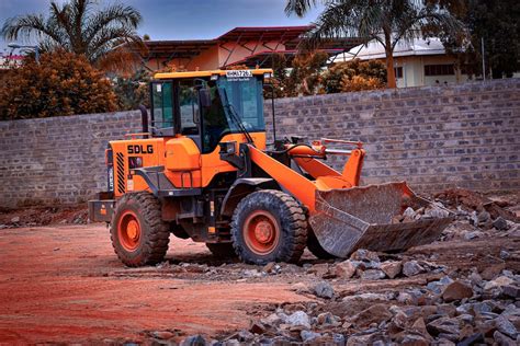 A Large Orange Bulldozer Sitting On Top Of A Dirt Field Photo Free
