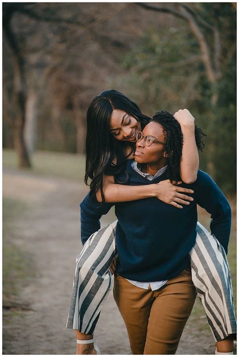 Two Women Hugging Each Other In The Middle Of A Path With Trees And