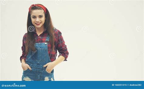 Lovely Pin Up Girl Standing Holding Hand In Her Jeans Pockets Posing Twirling Hair Around Her
