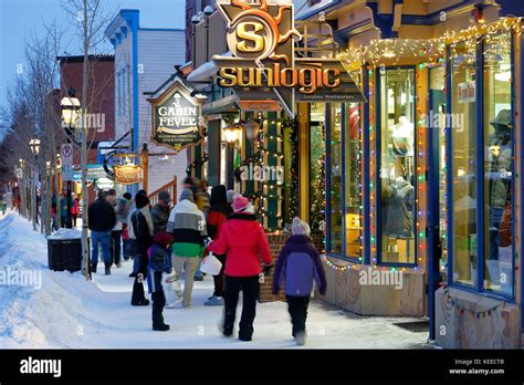 People Walking By Shops And Stores On Snow Covered Sidewalk