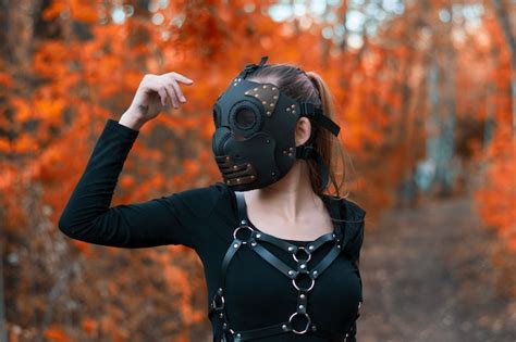 Premium Photo A Girl In A Bdsm Costume And A Black Mask In A Red