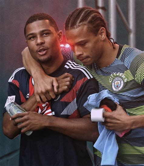 Two Soccer Players Hugging Each Other On The Sidelines With Their Arms