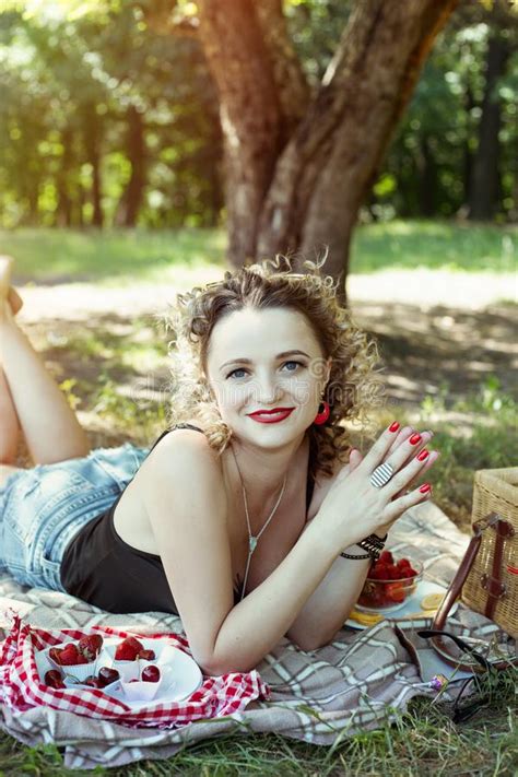 het sexy meisje met curvy haar en de zonnebril zijn op de picknick van de de zomerbes stock foto
