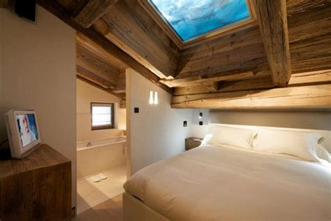 There Is A Bedroom With A Skylight Above The Bed And Television On The Wall