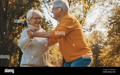 happy old couple dancing in park senior man flirting with elderly woman romance at old age
