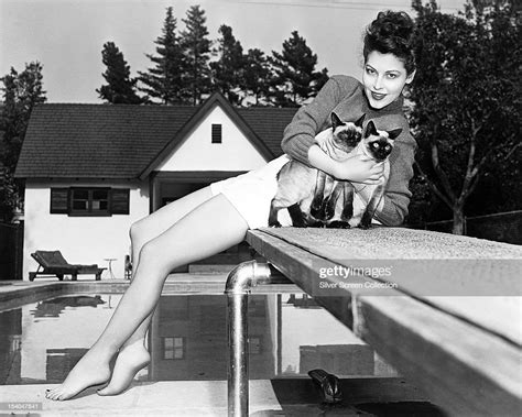American Actress Ava Gardner Sitting On A Diving Board And Holding A