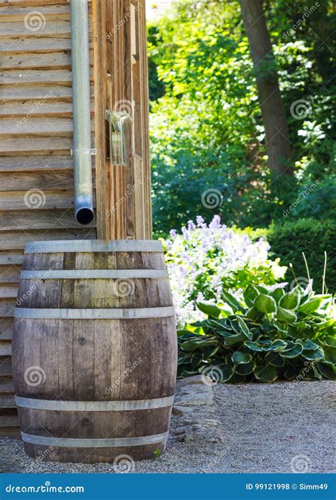 Wooden Rain Barrel Collecting Runoff From Roof Through Gutters Stock