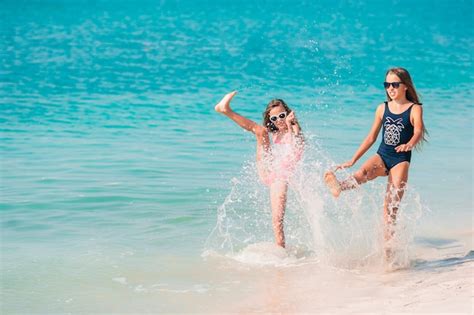 Las niñas divertidas y felices se divierten mucho en la playa tropical jugando juntas Foto