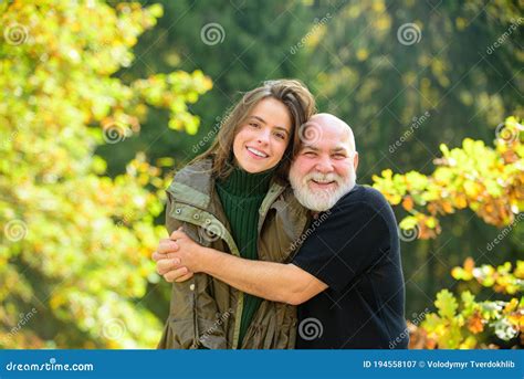 Grown Up Granddaughter With Elderly Grandfather Hugs Him Talking
