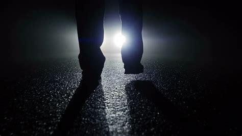 Fearless Person Walking Outdoors At Dark Night Following The Light