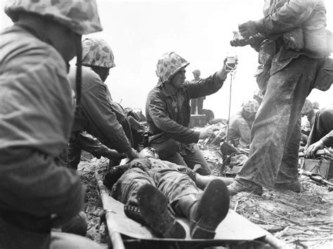 This Photo Shows A Navy Corpsman Giving A Wounded Marine Blood Plasma