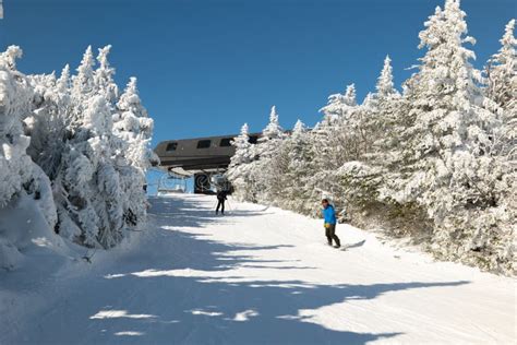 Skiers On Slope And Ski Lift With Snow Covered Trees Chairlift At