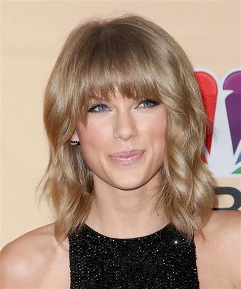 Taylor Swift Medium Wavy Caramel Blonde Hairstyle With Blunt Cut Bangs