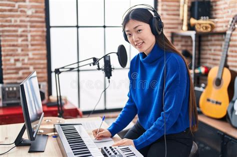 Chinese Woman Musician Composing Song At Music Studio Stock Photo