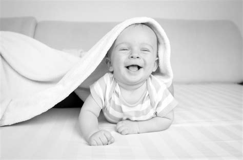 Premium Photo Portrait Of Happy Smiling Baby Lying On Bed With Rattle