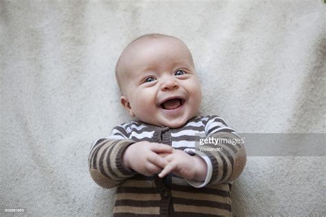 Portrait Of Laughing Baby Boy Lying On Blanket View From Above High Res