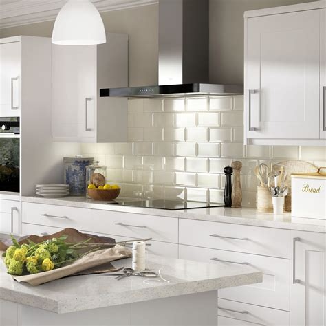 A Kitchen With White Cabinets And Marble Counter Tops Is Pictured In