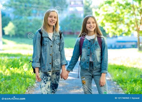 Two Girls Schoolgirl Summer In Nature They Hold Each Other`s Hands The Concept Best Friends