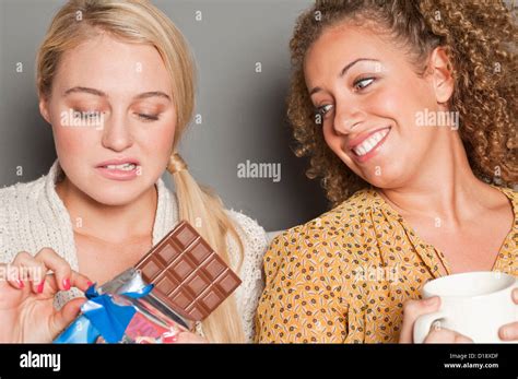 Woman Staring At Friend Holding Chocolate Stock Photo Alamy