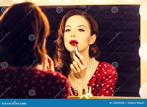 Portrait Of A Beautiful Woman As Applying Makeup Near A Mirror Stock