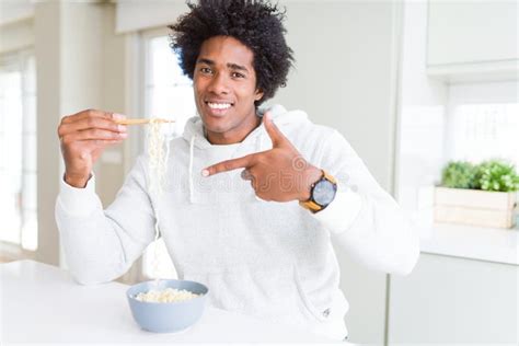 African American Man Eating Asian Noodles Using Chopsticks At Home Very