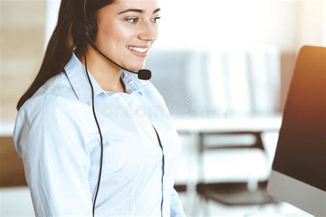 Brunette Female Customer Service Representative Using Headset And