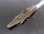 An aerial port beam view of the Kitty Hawk-class aircraft carrier USS ...