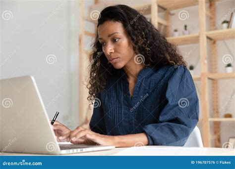 Serious Focused African American Businesswoman Using Laptop In Office